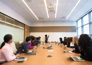 Business meeting around a conference table with someone gesturing while speaking
